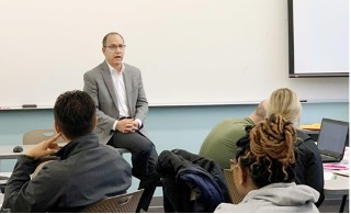 Bachelor program instructor speaking to class.