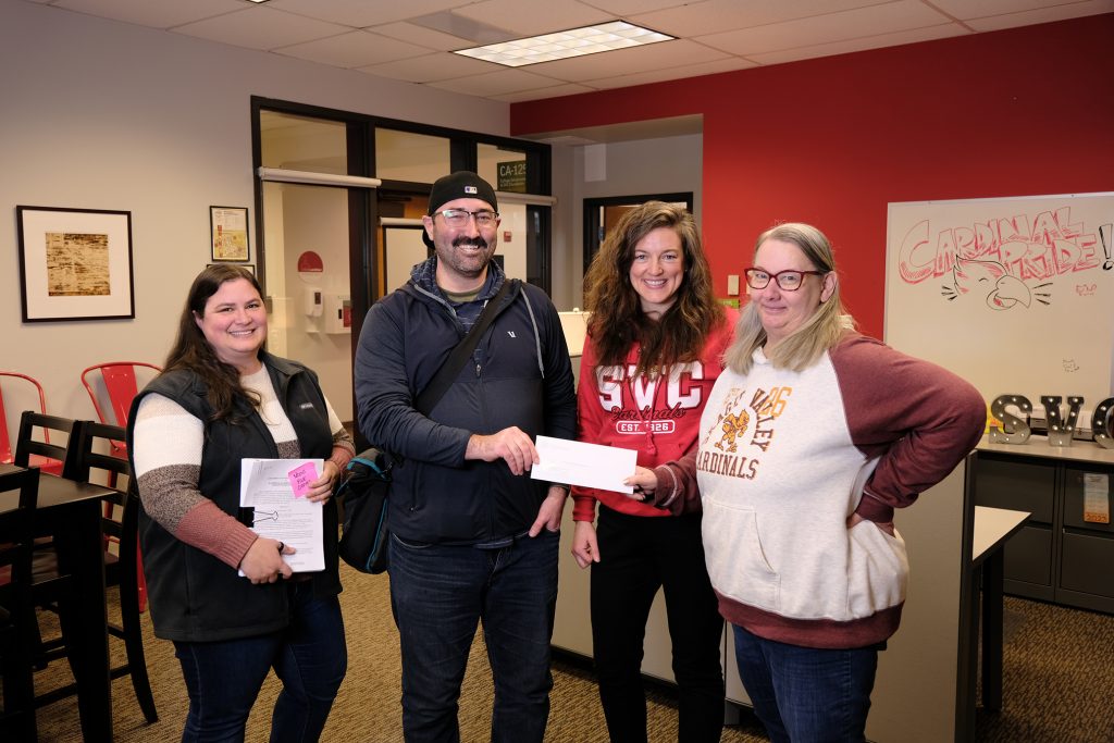 Michael Stark of the Seattle Foundation delivers a check for the fund to SVC Foundation staff: Kathy Eldred, Kathleen Petrzelka, and Tanna Baker