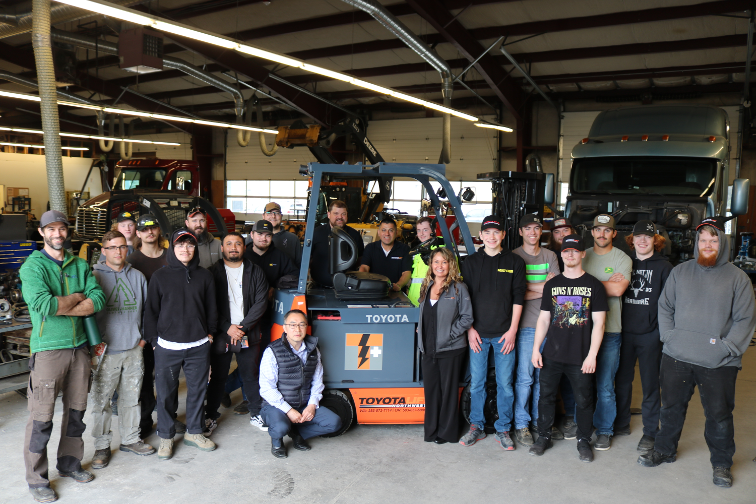 Diesel program students and instructors in front of donation with Kwang Yu, Director of Rentals and Service at Toyota Lift Northwest (kneeling).